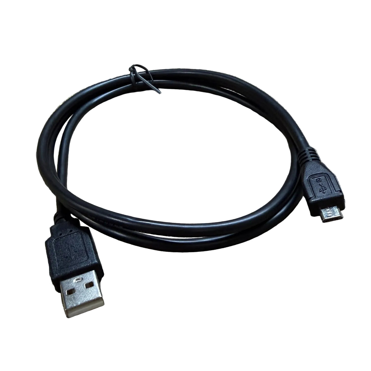 A black USB to Micro-USB cable coiled on a textured concrete floor.