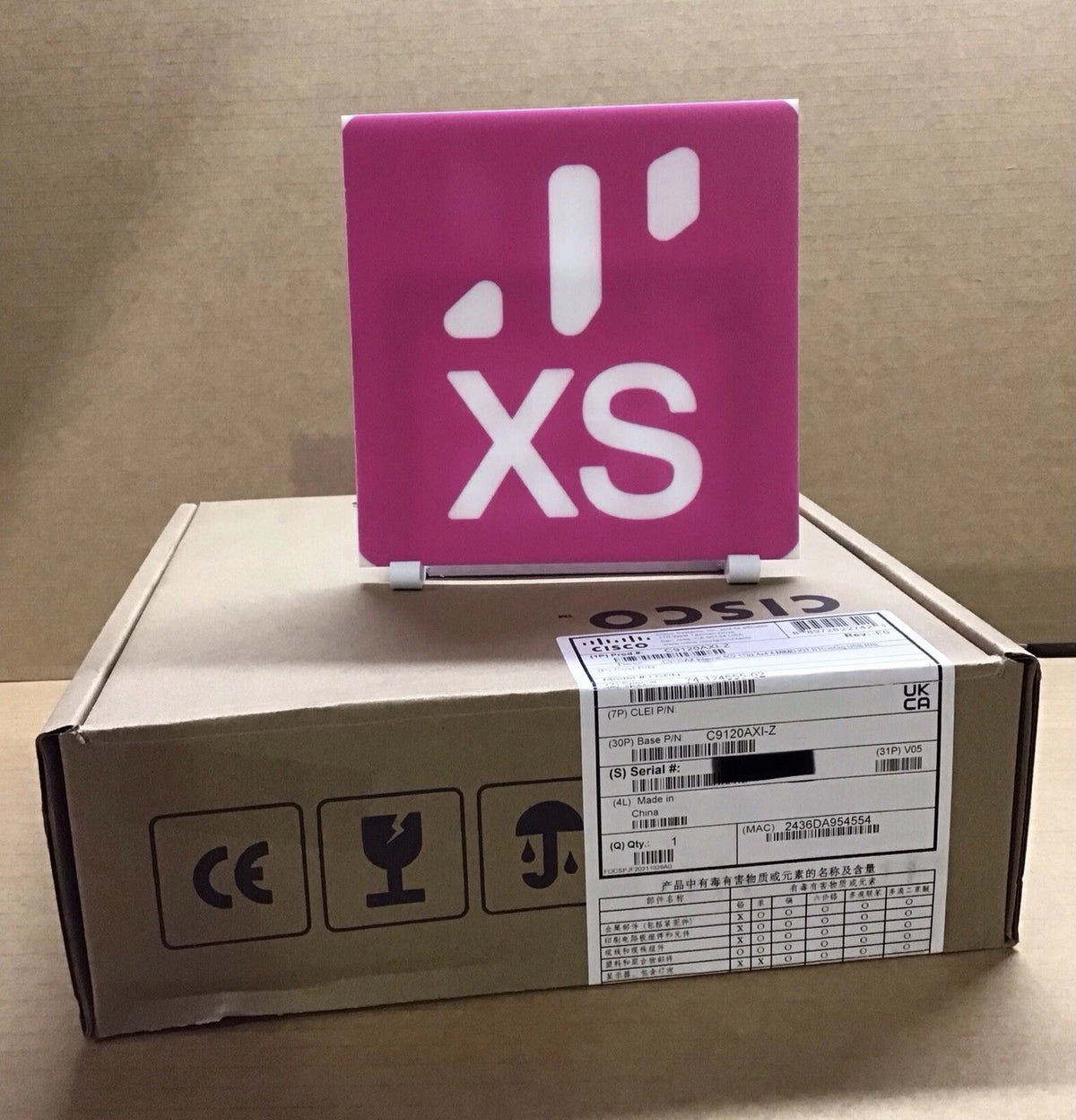 Pink cisco xs logo plaque on cisco c9120axe-z wi-fi 6 external antenna device showing product branding
