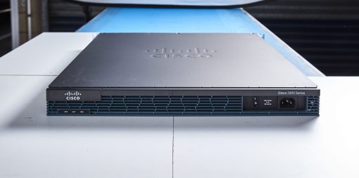 Cisco 2901-K9 router with black chassis, silver accents, on blue surface